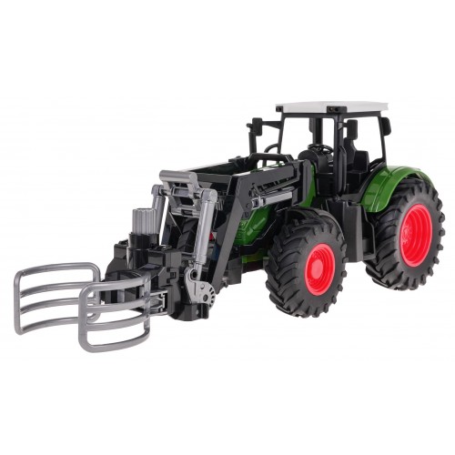 Zelený traktor s drapákom