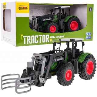 Zelený traktor s drapákom