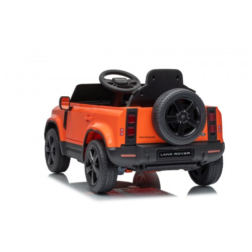 Oranžové vozidlo Land Rover Defender