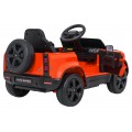 Oranžové vozidlo Land Rover Defender